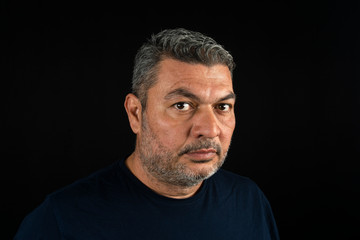 Portrait of man in his 40s who started to gray hair with an expressionless look.