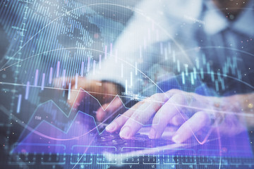Forex graph with businessman working on computer in office on background. Concept of hardworking....