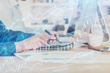 Forex graph with businessman working on computer in office on background. Concept of hardworking. Closeup. Multi exposure.