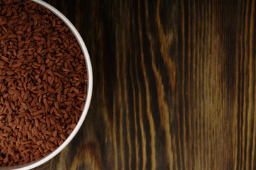 Red Rice seed. Top view of grains in a bowl, copy space