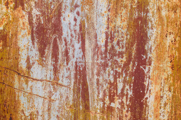 Old paint on a metal wall. Multicolor - white, yellow, blue, burgundy, green. Inflows, swelling, cracks.