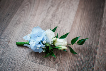 White with blue rose buttonhole on the table