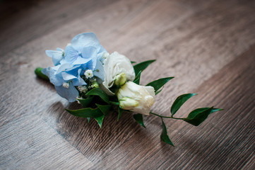 White with blue rose buttonhole on the table
