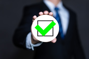 Businessman holding check mark with a green marker, confirmed or approved concept