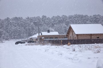 Village street in winter in snowfall