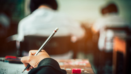 Hand of Student doing test or exam  in classroom of school with stress