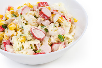 Salad of crab sticks with vegetables in bowl, fragment closeup