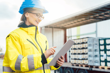 Supervisor checking contents of shipment to be sent by truck