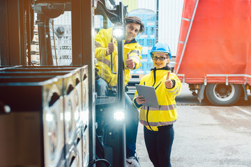 Forklift driver and forewoman discussing where to store delivery