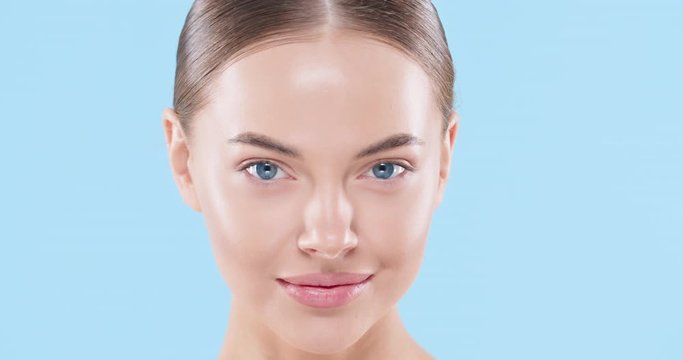 Beauty woman face isolated on blue background. Skin care. Beautiful female model with perfect clean fresh skin