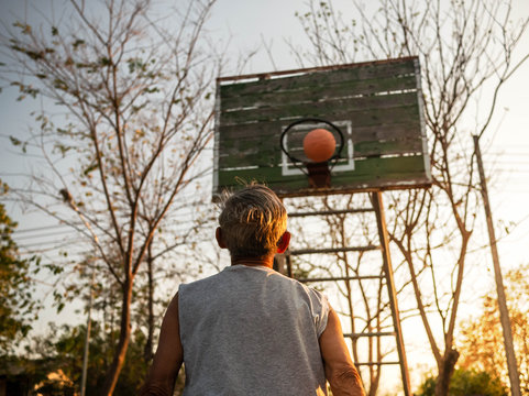 Asian Elderly Men Playing Basketball On Playground On Summer Day. Healthy Lifestyle And Healthcare Concept.