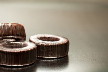 Close-up round transformer wrapped in wire lie on the table on top of each other. The concept of...