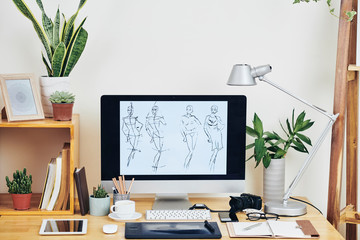 Workplace of illustrator with line female figures on computer screen, planners, plans and devices