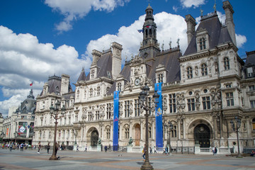 Fototapeta na wymiar The Hotel de Ville - the city's local administration, Renaissance Revival style. Beautiful sunny day. Paris City Hall against the blue sky with white cumulus clouds.