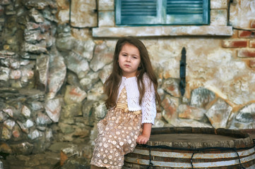 Beautiful fashionable little girl in the city . Model children .