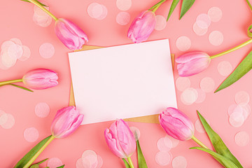 View from above tulips and blank of paper with copy space. Background for womens day, 8 March Valentines day, 14 february. Flat lay style, top view, mockup, template, overhead. Greeting card