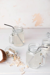 Mason jars of fresh coconut water on table