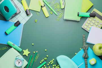 Set of school stationery on green background