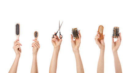 Many hands with hairdresser's supplies on white background