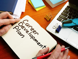 Employee is writing career development plan by pen.