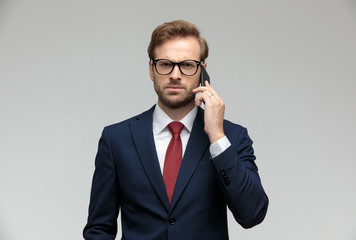 businessman talking on the phone while looking at camera angry