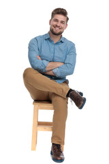 happy casual man in denim shirt smiling and crossing arms