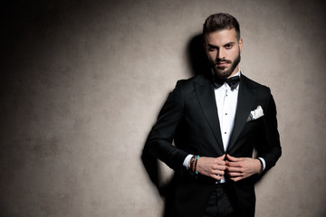 sexy young elegant model adjusting coat in a fashion light