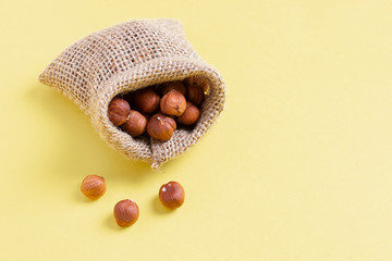 Hazelnuts, filbert in burlap sack on wooden backdrop. heap or stack of hazelnuts. Zero waste concept, healty food