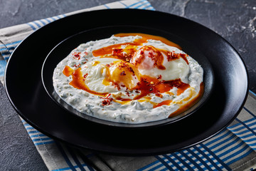 close-up of cilbir, poached eggs in yogurt sauce