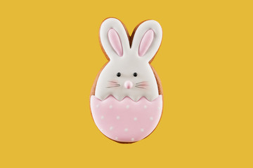 Gingerbread cookie in shape of bunny on yellow background