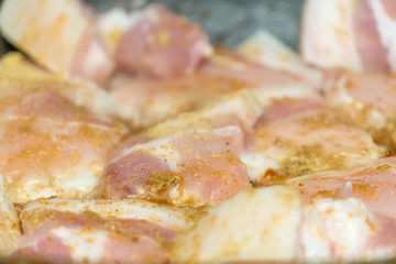 Pieces of meat are fried in a pan in oil close up