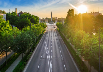Budapest, Hungary - Aerial drone view of totally empty Andrassy street at sunrise with green trees...