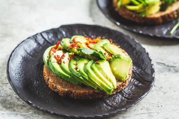 Avocado toast with whole grain bread, top view. Healthy vegan food concept.