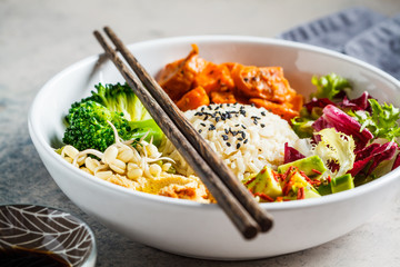 Vegan rice and vegetables salad. Macrobiotic set with rice, hummus, avocado, broccoli and sweet potato.