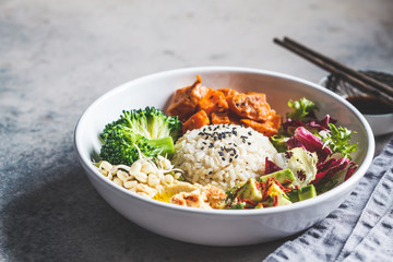 Vegan rice and vegetables salad. Macrobiotic set with rice, hummus, avocado, broccoli and sweet potato.