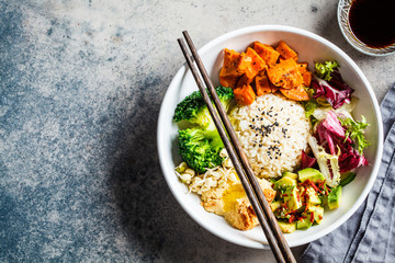 Vegan rice and vegetables salad. Macrobiotic set with rice, hummus, avocado, broccoli and sweet potato.