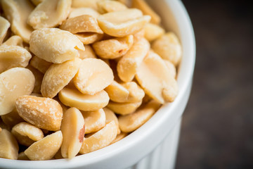 Salted peanuts on rustic background. Selective focus. Shallow depth of field.