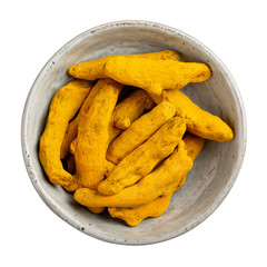 Dried turmeric roots  in ceramic bowl isolated on white background. Top view.