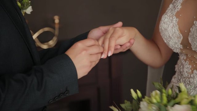 Newlyweds put rings on a finger to each other.