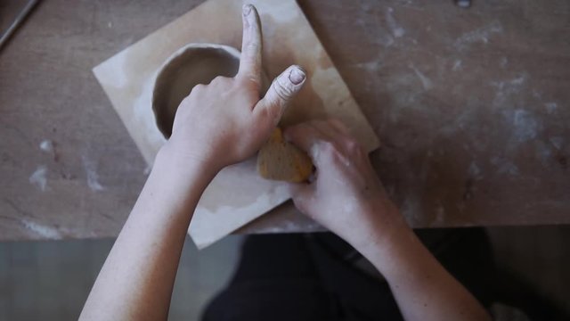 Female potter forming a bowl, from above