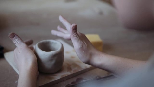 Close-up of female potter forming a bowl