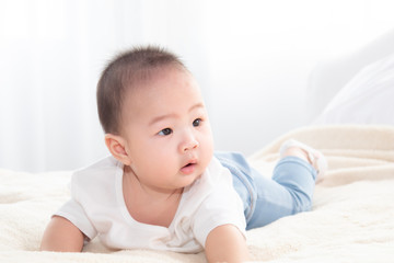Asian cute adorable baby healthy boy good mood smiling laughing lie down on bedroom upturn playing with camera or mother, baby toddler, infant childhood soft skin happy face expression looking mom