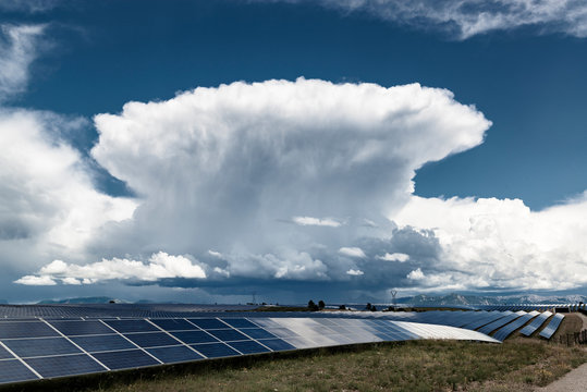 Power of nature. Solar power plant and big growing thunderstorm cloud.