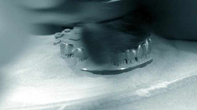 Man is cleaning wit brush object printed on 3d metal printer