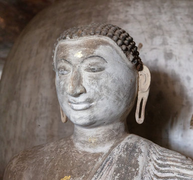Smiling Buddha portrait insides in ancient Buddhist complex in Dambulla cave temple in Sri Lanka.