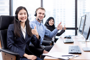 Group of ethnic diversity call center are thumbs up with friendly face in the office. Call center...