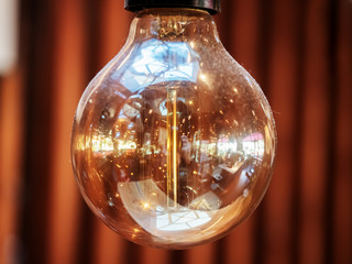 Close-up photo of a transparent light bulb with an interior reflected in it