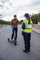 policeman stops a boy on electric scooter