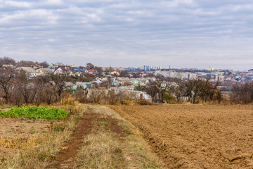 Plowed field at autumn. City Uman on a background. Ukraine