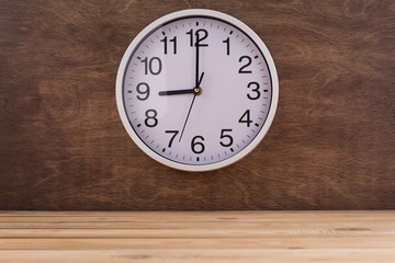 wall clock at wall near wooden table